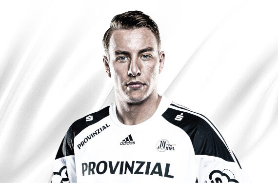 Ein männlicher Sportler mit kurzen hellbraunen Haaren trägt ein weiß-schwarzes Sporttrikot mit der Aufschrift PROVINZIAL und verschiedenen Logos auf der Vorderseite. Er steht vor einem weißen Hintergrund und blickt direkt in die Kamera.