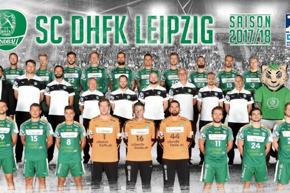 Ein Mannschaftsfoto der Handballspieler und -mitarbeiter des SC DHfK Leipzig in grünen und schwarzen Trikots für die Saison 2017/18, die in einer Reihe mit einem Maskottchen auf der rechten Seite stehen. Im Hintergrund sind der Mannschaftsname und die Sponsoren zu sehen.