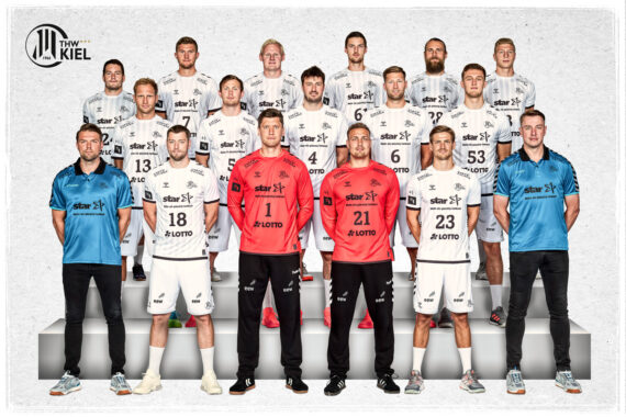 Eine Gruppe von 18 männlichen Handballspielern des THW Kiel posiert in Uniform, angeordnet in drei Reihen. Die meisten tragen weiße Trikots, zwei tragen rote und einer blaue Trikots. In der linken oberen Ecke ist das Logo des THW Kiel zu sehen.