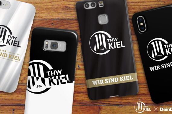 Vier Smartphone-Hüllen auf einer Holzoberfläche, jeweils mit dem Logo der Handballmannschaft des THW Kiel und dem Slogan WIR SIND KIEL in Gold. Die Hüllen sind schwarz, weiß oder ein Mix aus schwarz und weiß.