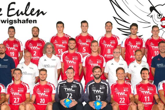 Eine Handballmannschaft in roten Trikots posiert für ein Gruppenfoto mit ihren Trainern und Betreuern vor einem weißen Hintergrund mit einer Eulen-Karikatur und dem Text Die Eulen Ludwigshafen. Auf der linken Seite steht die Saison 2018/2019.