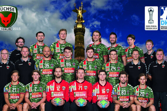 Ein Gruppenfoto der Handballmannschaft der Füchse Berlin in grünen Trikots mit ihren Trainern vor der Berliner Siegessäule und einem dramatischen Himmel, auf dem die Logos der Mannschaften und Sponsoren zu sehen sind.