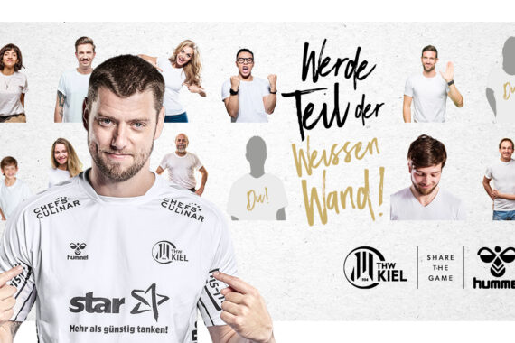 Ein männlicher Sportler im weißen THW Kiel-Trikot zeigt auf sich selbst, umgeben von jubelnden Fans, die das gleiche Trikot tragen. Der deutsche Text und die Logos der Sponsoren sind sichtbar und werben für das neue Heim-/Auswärtstrikot der Mannschaft für 2020/21.