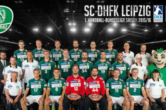 Mannschaftsfoto der Handballmannschaft 2015/16 des SC DHfK Leipzig, einschließlich Trainer und Maskottchen, alle in grün-weißen Trikots, stehend und sitzend in Reihen in einer Sporthalle.