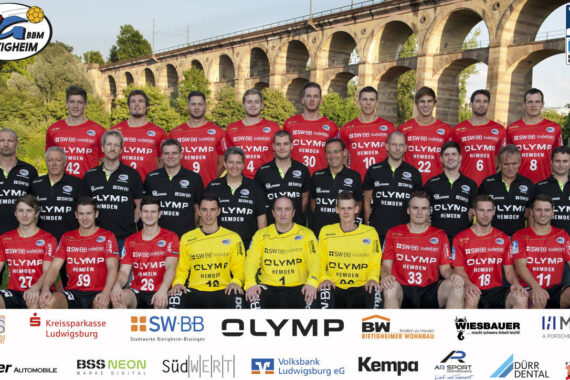 Eine Herrenhandballmannschaft posiert im Freien vor einem großen Steinviadukt. Die meisten Spieler tragen rote Trikots, einige wenige auch gelbe oder schwarze. Am unteren Rand des Bildes sind die Logos der Sponsoren zu sehen.