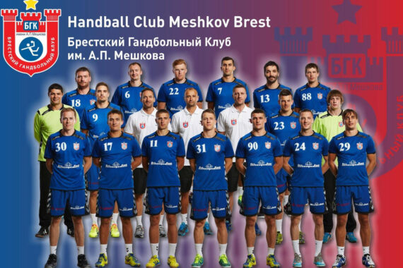 Ein Gruppenfoto von Spielern und Mitarbeitern des Handballclubs Meshkov Brest in blauen Uniformen, die in Reihen vor einem rot-blauen Hintergrund mit dem Clublogo und kyrillischem Text stehen.