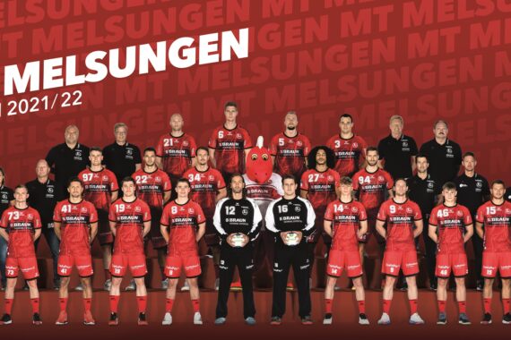Die Handballer der MT Melsungen posieren für ein Gruppenfoto in ihren roten Trikots für die Saison 2021/22, mit Trainern und Betreuern in Schwarz, vor einem roten Hintergrund mit MT Melsungen und dem Vereinslogo.