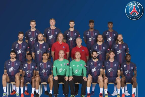 Gruppenfoto der Handballmannschaft und des Personals von Paris Saint-Germain in marineblauen Uniformen, die in drei Reihen vor einem blauen Hintergrund mit dem PSG-Logo in der rechten oberen Ecke angeordnet sind.