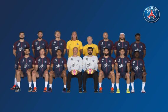 Ein Gruppenfoto der Handballmannschaft und des Personals von Paris Saint-Germain, alle in Mannschaftsuniformen, sitzend und stehend in Reihen vor einem blauen Hintergrund mit dem PSG-Logo in der rechten oberen Ecke.