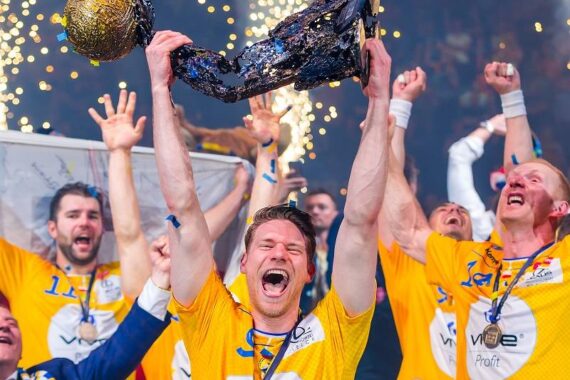 Eine jubelnde Sportmannschaft in gelben Trikots feiert den Sieg, wobei ein Spieler inmitten von Konfetti und funkelnden Lichtern eine Trophäe in die Höhe reckt. Die Spieler jubeln enthusiastisch, zeigen Aufregung und Freude.