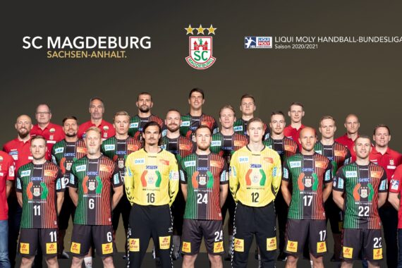 Ein Gruppenfoto der Handballmannschaft des SC Magdeburg mit Spielern und Betreuern, die in Reihen stehen und alle Mannschaftsuniformen tragen. Das Logo und der Text des SC Magdeburg erscheinen über ihnen auf einem dunklen Hintergrund.
