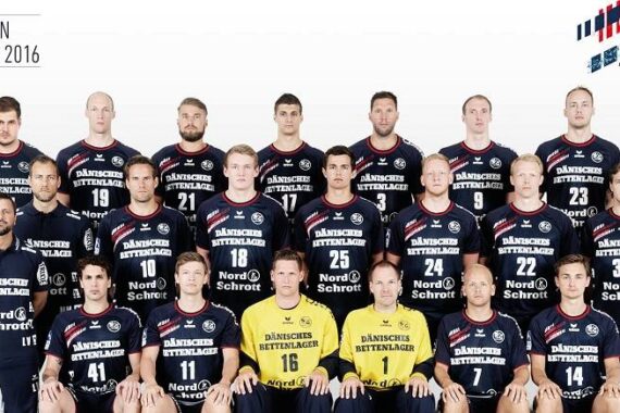 Eine Handballmannschaft der Männer posiert für ein Gruppenfoto in marinefarbenen Trikots mit der Aufschrift "DÄNISCHES BETTENLAGER" auf der Vorderseite. Drei Trainer oder Betreuer in Gelb sitzen in der ersten Reihe. Der Text lautet "Saison 2015/2016" und "SG Flensburg-Handewitt".