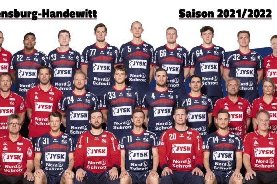 Gruppenfoto der Handballmannschaft der SG Flensburg-Handewitt für die Saison 2021/2022. Die Spieler und Betreuer in ihren rot-blauen Trikots stehen in einer Reihe vor einem Hintergrund mit Mannschaftslogos und -farben.