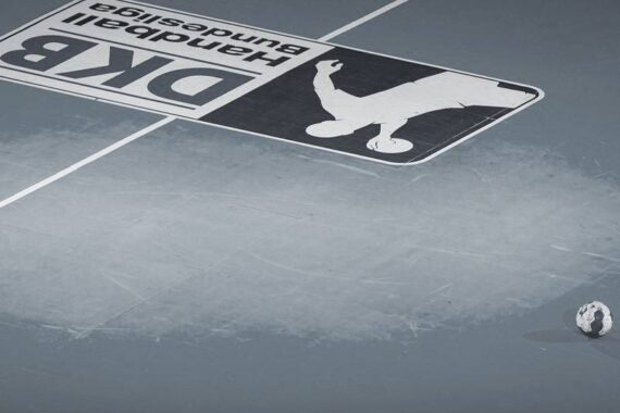 Ein Handball liegt auf einem leeren Hallenplatz nahe der Mittellinie, neben einem großen, auf den Boden gemalten Logo der DK Handball-Bundesliga. Die Szene ist minimalistisch mit einer gedämpften Farbpalette.