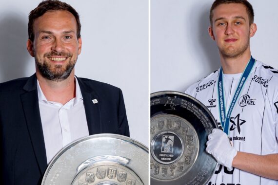 Zwei Männer posieren mit großen silbernen Meisterschaftstellern. Der Mann auf der linken Seite trägt einen schwarzen Anzug und hält den Teller lächelnd vor sich. Der Mann auf der rechten Seite trägt ein weißes Sporttrikot, eine Medaille und weiße Handschuhe und hält ebenfalls einen Teller.