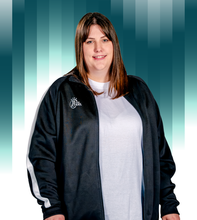 THWKiel-Jana_Michaels-Hauswaldt Eine Frau mit glattem braunem Haar, die eine schwarz-weiße Sportjacke über einem weißen Hemd trägt, steht und lächelt vor einem Hintergrund mit blaugrünem und weißem Farbverlauf und vertikalen Balken.