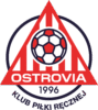 REBUD KPR Ostrovia Ostrów Wielkopolski_schwarz Ein rot-weißes dreieckiges Logo mit einem Fußball in der Mitte, darunter das Wort OSTROVIA, die Jahreszahl 1996 und der Text KLUB PIŁKI RĘCZNEJ in einem kreisförmigen Rahmen am unteren Rand.