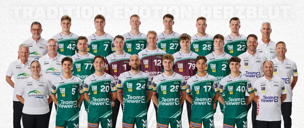 FRISCH AUF! GÖPPINGEN (45 x 29 cm) - 2 Eine Herren-Volleyballmannschaft und ihre Betreuer posieren für ein offizielles Gruppenfoto. Alle tragen grüne, weiße oder kastanienbraune Trikots mit Sponsorenlogos und stehen oder knien in Reihen vor einem weißen Hintergrund.