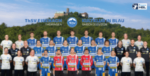 Ein Gruppenfoto der Handballer des ThSV Eisenach in blau-weiß-rot-schwarzen Trikots, die im Freien vor einer historischen Burg auf einem Hügel stehen, mit Grün im Hintergrund. Mannschafts- und Sponsorenlogos sind zu sehen.
