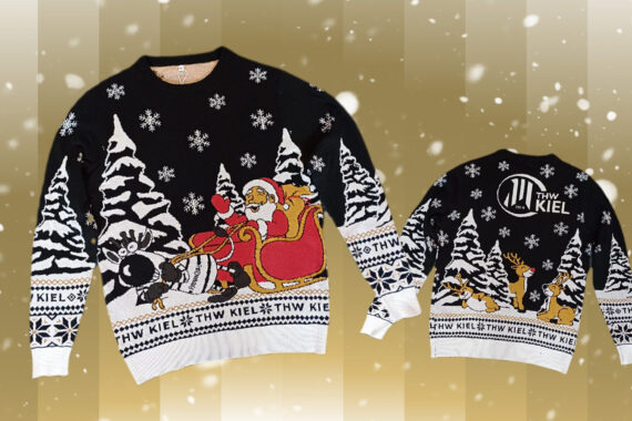 Ein festlicher schwarz-weißer Weihnachtspulli aus dem THW Kiel Fanshop mit dem Weihnachtsmann im Schlitten, der von einer Robbe gezogen wird, verschneiten Bäumen und dem Schriftzug THW KIEL. Die Rückseite zeigt einen Hirsch, das Logo und Schneeflocken - der perfekte Fanartikel für die Handball-Saison 2025/2026.