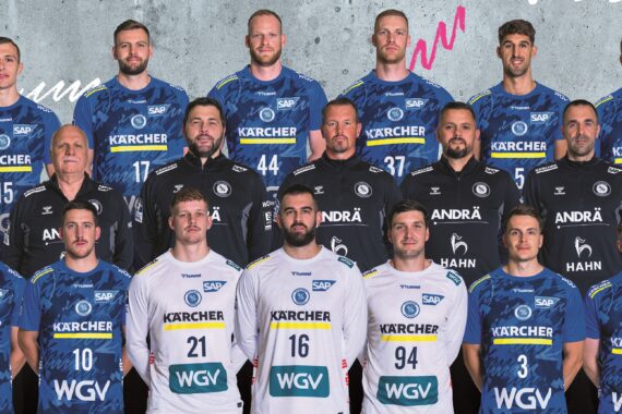 Eine Handballmannschaft der Männer posiert für ein Gruppenfoto in blau-weißen Trikots mit Sponsorenlogos. Die Spieler stehen in drei Reihen, Trainer und Betreuer in der mittleren Reihe, alle lächeln vor einem grauen und bunten abstrakten Hintergrund.