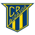 Ein blaues und gelbes schildförmiges Logo mit C.P. BIDASOA in gelber Diagonalschrift und drei senkrechten gelben Streifen am unteren Rand.