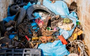 Ein Haufen Müll in einem Müllcontainer, darunter alte Reifen, blaue Plastiksäcke, verhedderte Seile und Schutt - das verdeutlicht die Notwendigkeit von Projekten wie För de Küste und Meeres- und Küstenschutz, die von der Handball-Bundesliga des THW Kiel unterstützt werden.