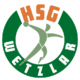Logo der HSG Wetzlar, das einen stilisierten Handballspieler in Bewegung in einem grün-weißen Kreis zeigt. Oben steht in orangefarbener Schrift HSG, um die untere Kurve herum steht in weißer Schrift WETZLAR.
