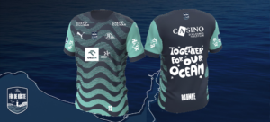 Ein blaugrünes und dunkelblaues Fußballtrikot mit Wellenmustern, mehreren Sponsorenlogos und dem Slogan "Together for our Ocean" auf dem Rücken, der auf einem Hintergrund mit Meeresmotiven abgebildet ist.