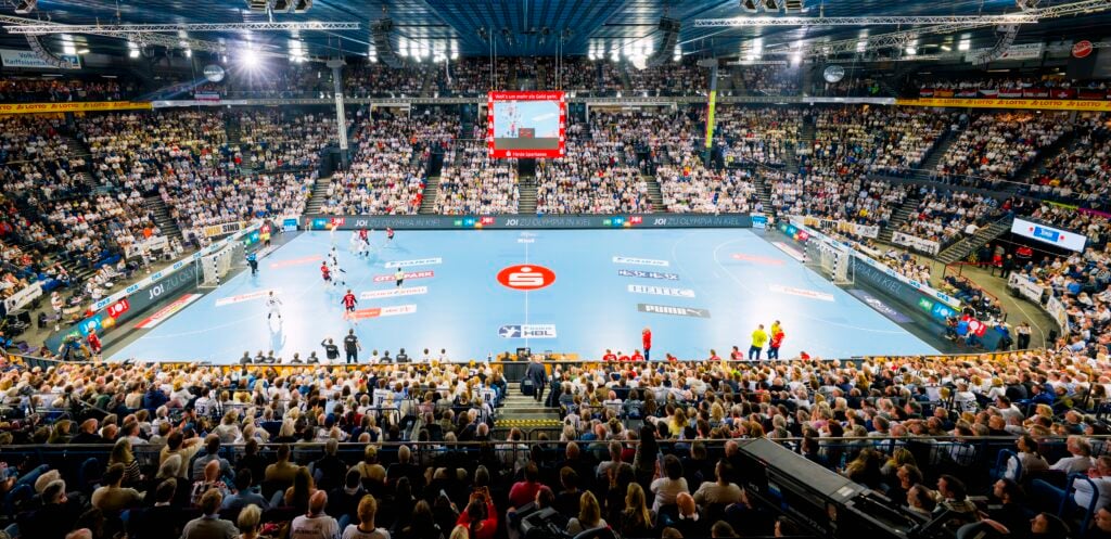 HANDBALL 2025/26: THW Kiel - SG Flensburg-Handewitt Eine große Sporthalle, vollgepackt mit Zuschauern, die ein Handballspiel verfolgen; die Mannschaften spielen auf einem blauen Spielfeld, und über dem Spielfeld befindet sich eine Anzeigetafel.