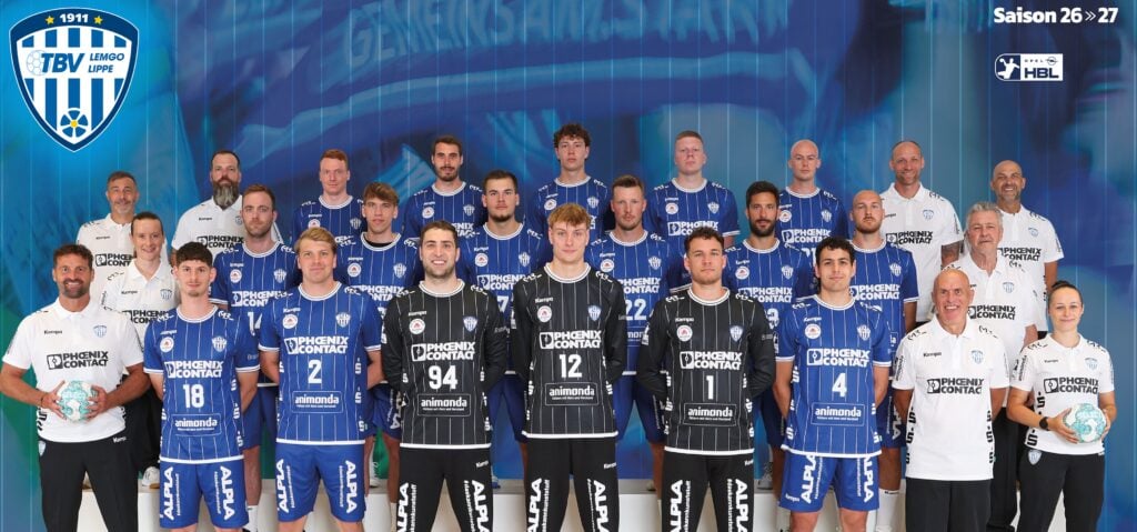 Gruppenfoto einer Handballmannschaft in blau-schwarzen Trikots, wobei die Trainer vor einem blauen Hintergrund stehen und knien; oben rechts sind das TBV Lemgo Lippe-Logo und die Aufschrift „Saison 26•27“ zu sehen.