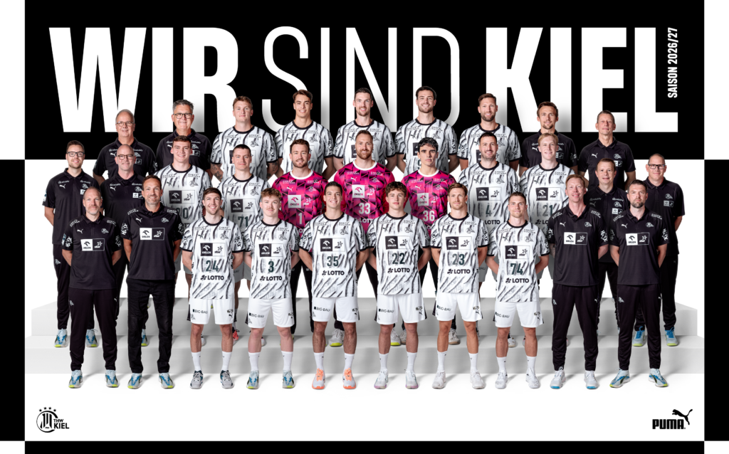 Die Mannschaft des THW Kiel posiert zusammen mit den Trainern für ein Gruppenfoto in schwarzen und weißen Trikots; hinter ihnen stehen in großen Buchstaben die Aufschriften „WIR SIND KIEL“ und „SAISON 2022/23“, die den Teamgeist des Handballkaders bei den Vorbereitungen auf die kommende Saison 2024/25 widerspiegeln.
