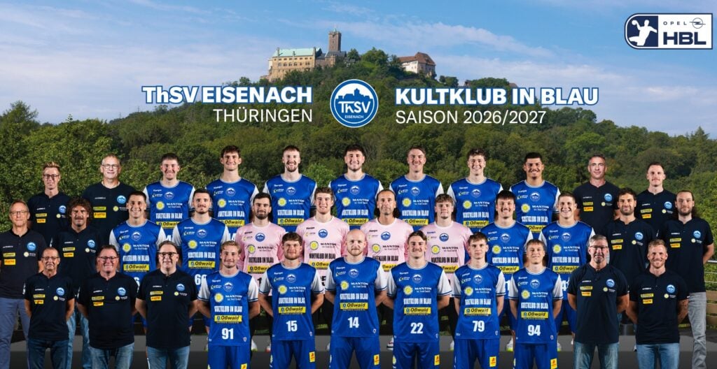 EIS_Teambild_45x29cm - 2 Mannschaftsfoto der Handballspieler und Betreuer des ThSV Eisenach in blau-weißen Trikots, die im Freien vor der Kulisse der Wartburg und von Bäumen posieren, unter Bannern mit dem Vereinsnamen und Informationen zur Saison 2026/2027.