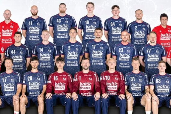 Eine Herren-Handballmannschaft posiert in blauen und roten Trikots für ein Gruppenfoto. Vier Reihen aus Spielern und Betreuer stehen und sitzen vor einem hellen Hintergrund.