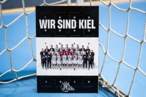 Ein Adventskalender des THW Kiel mit einem Mannschaftsfoto unter dem Titel WIR SIND KIEL, aufgenommen vor einem Handballtor.
