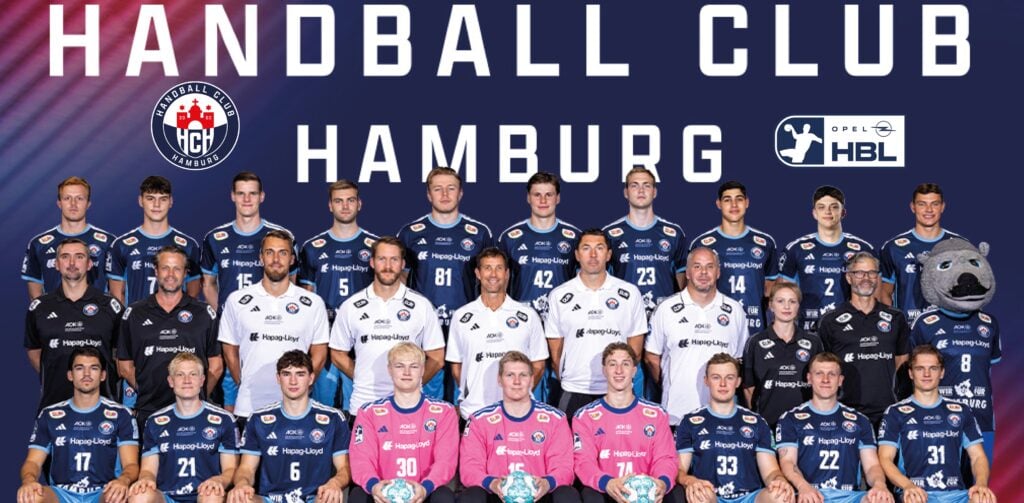 26_vor_HCH_Teambild_Titel Gruppenfoto der Mannschaft und des Stabs des Handball Clubs Hamburg in Trikots, wobei die Spieler in Reihen stehen und sitzen; rechts ist ein Maskottchen zu sehen. Der Text darüber lautet Handball Club Hamburg. Im Hintergrund sind Logos zu sehen.