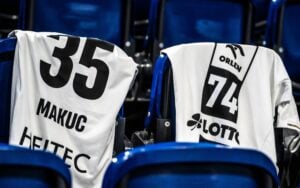 Zwei Sporttrikots mit den Nummern 35 und 74 lagen über den blauen Stadion-Sitzen.